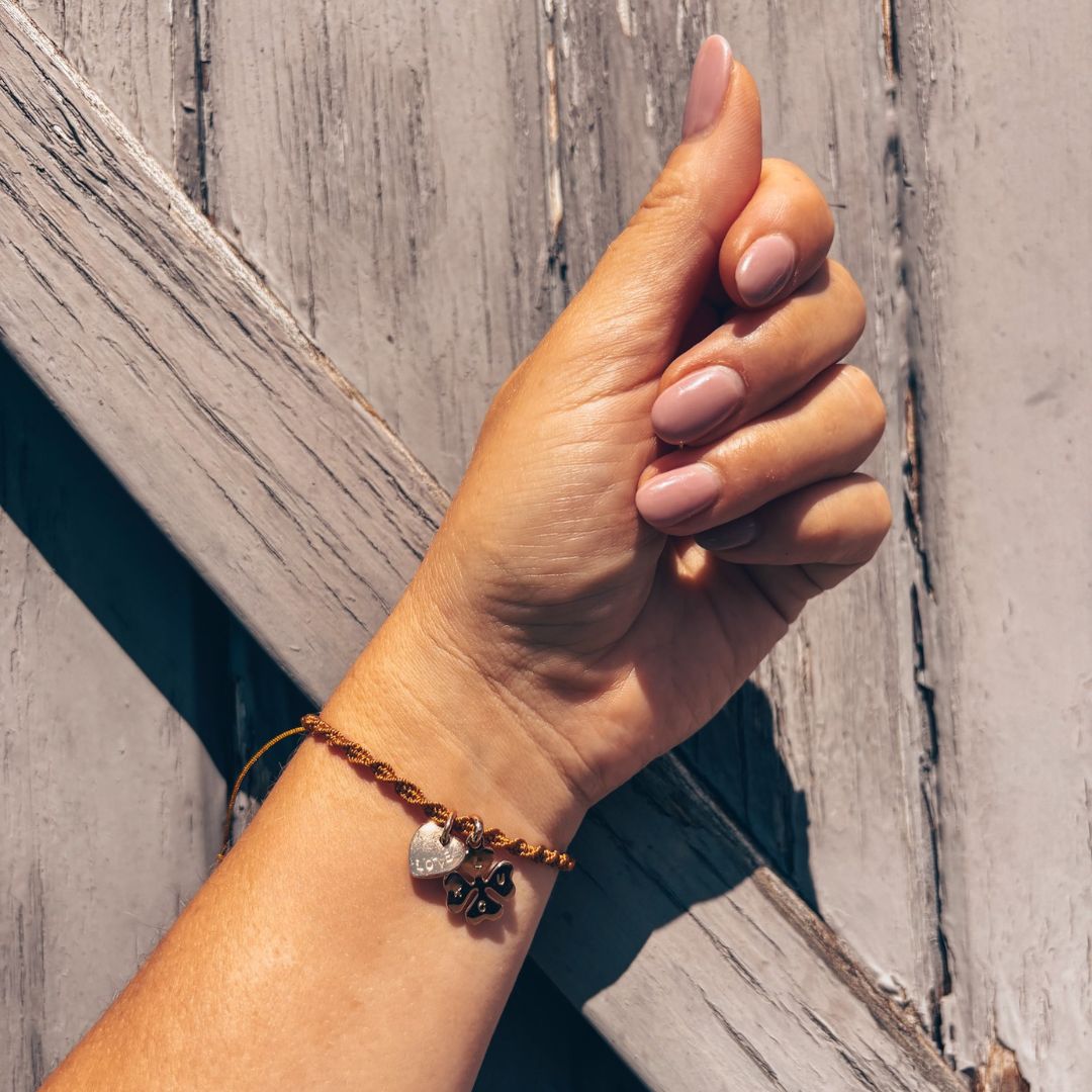 Bracelet Talisman du Soleil porté au poignet, breloques cœur et trèfl