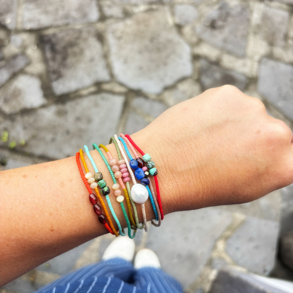 Ensemble de bracelets hippy colorés avec perles naturelles porté en stacking au poignet