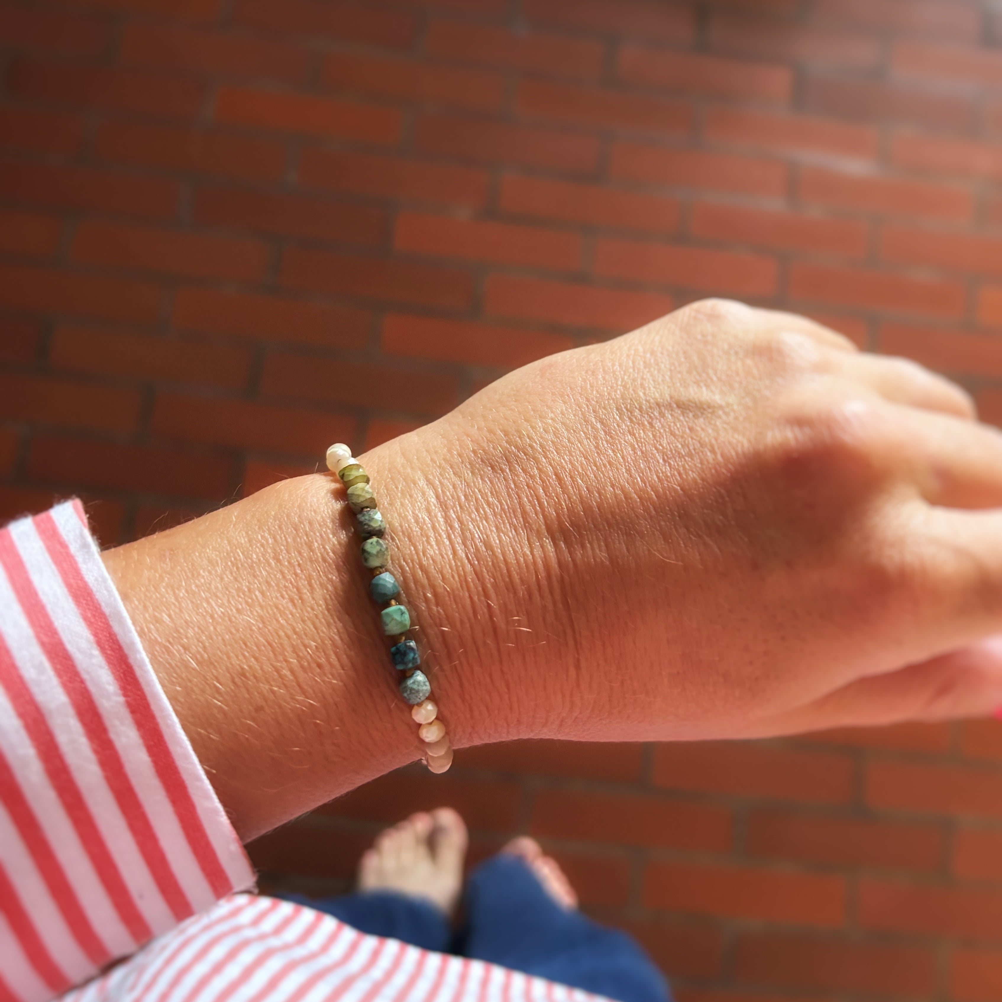 Bracelet Signature porté au poignet, perles de nacre et turquoise naturelle