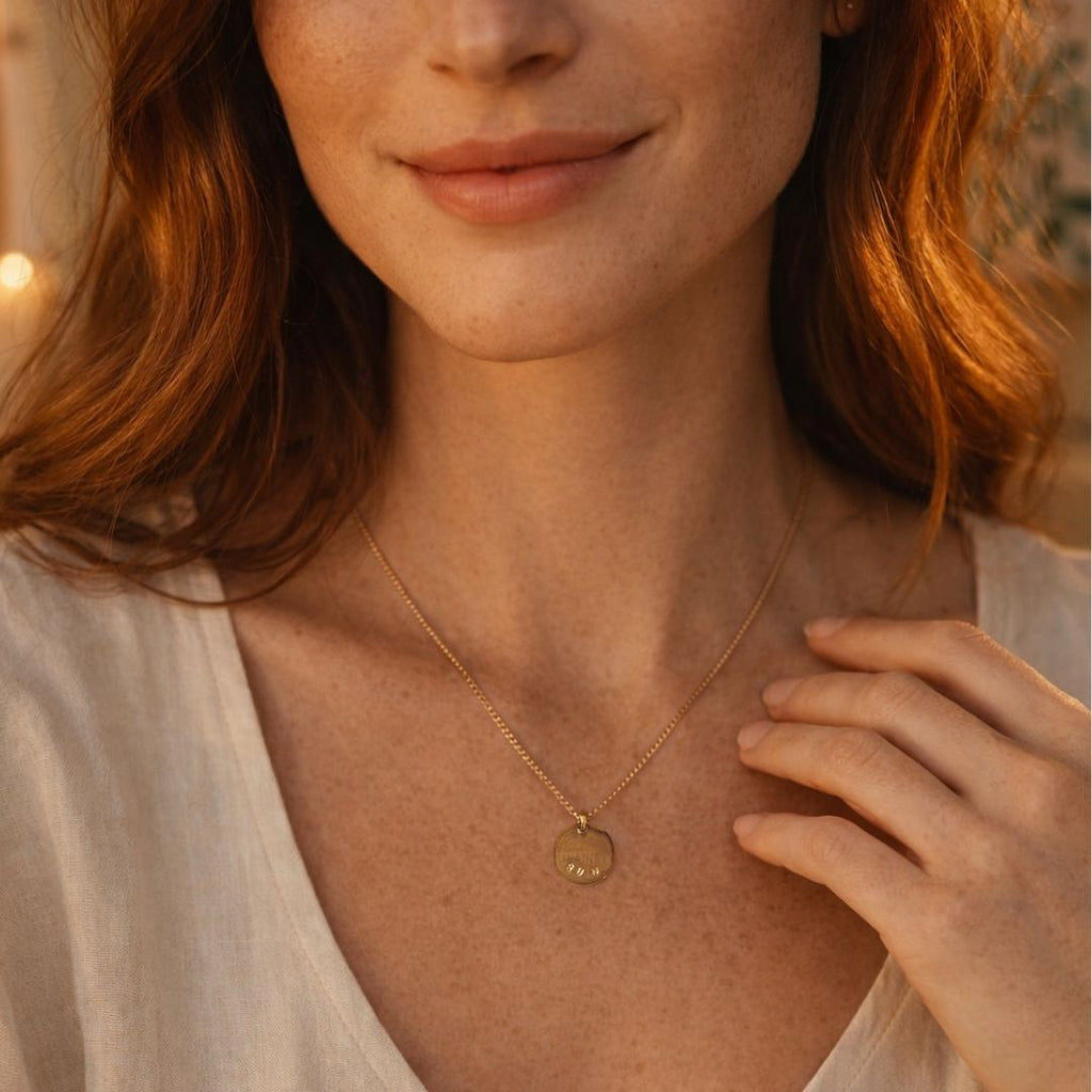 Femme rousse qui porte un collier avec un message soleil gravé à la main
