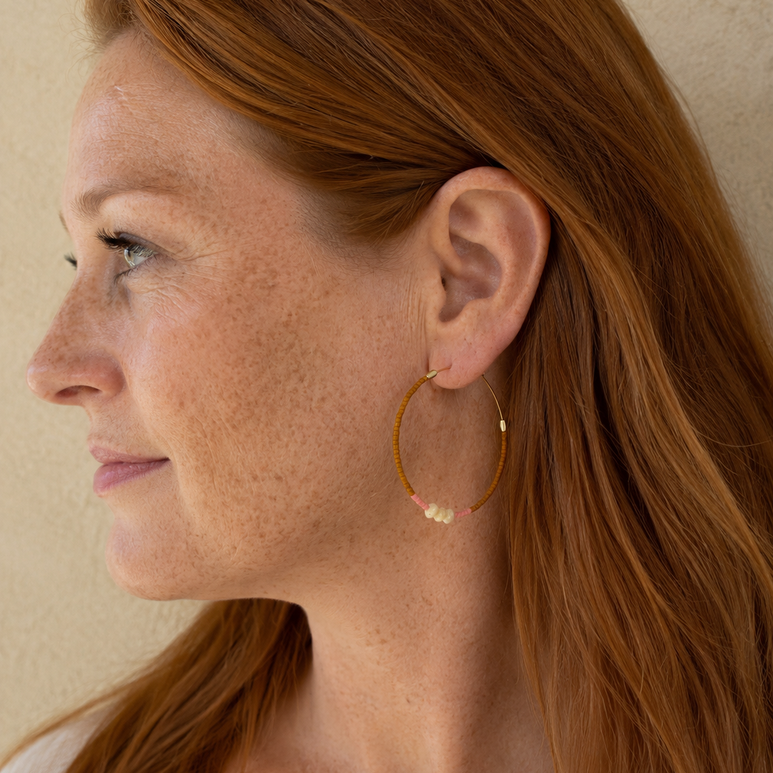 Créoles de MarlaH bijoux fabrication belge portée sur une belle femme rousse