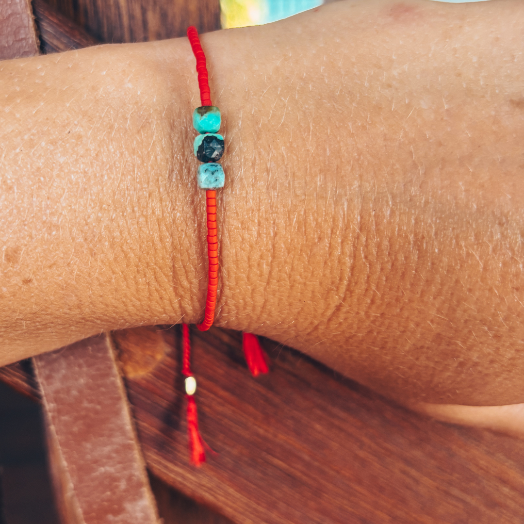 Bracelet hippy soie rouge et turquoise porté au poignet