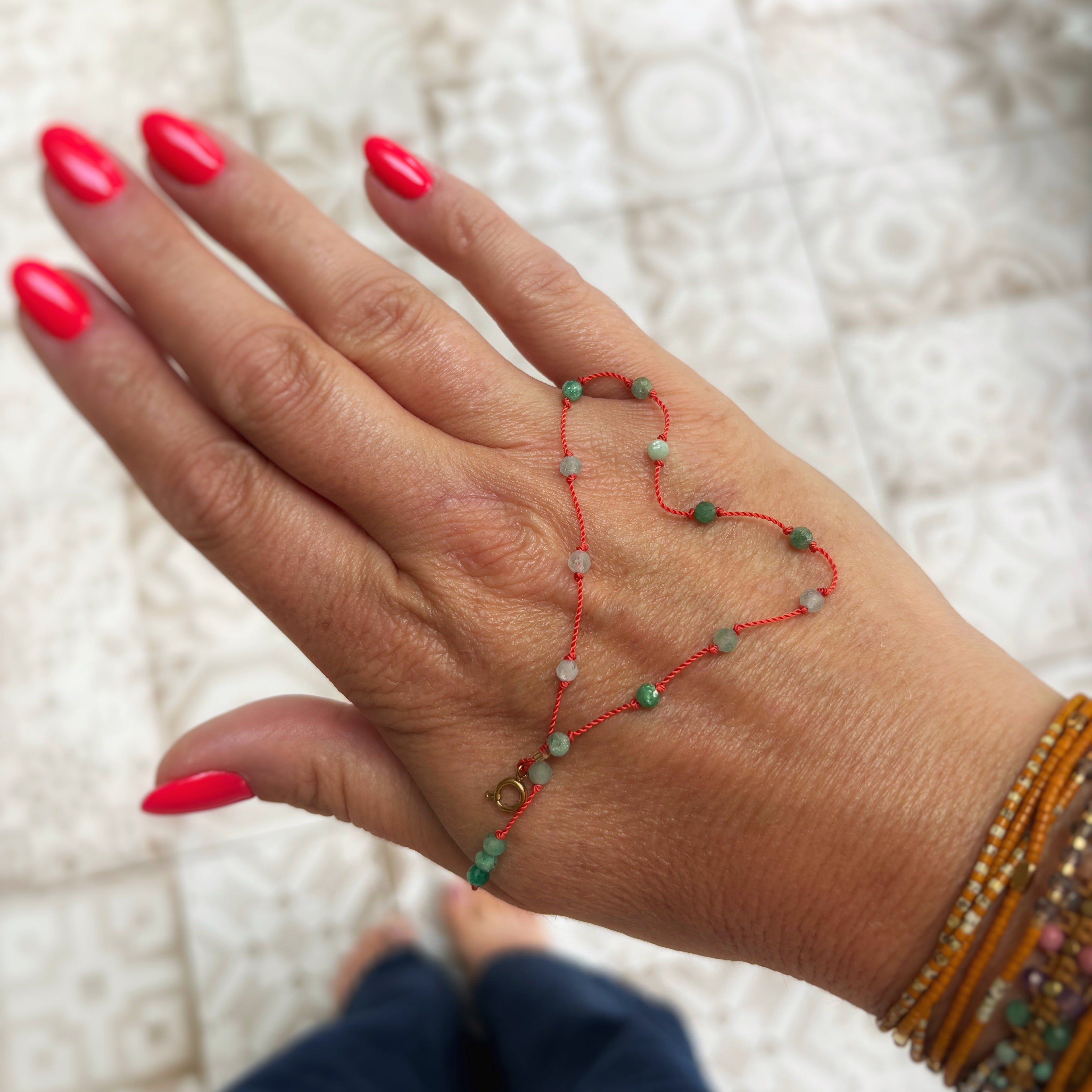 Bracelet Le Lien en émeraude naturelle drapé dans la main