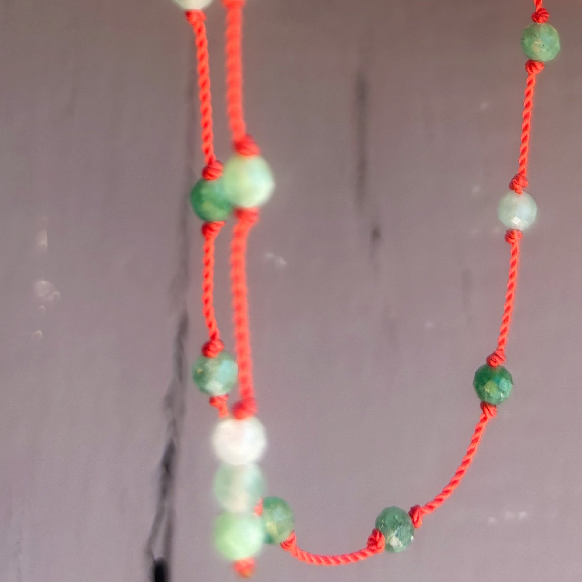 Détail des perles d'émeraude naturelle nouées à la main sur le collier Le Lien