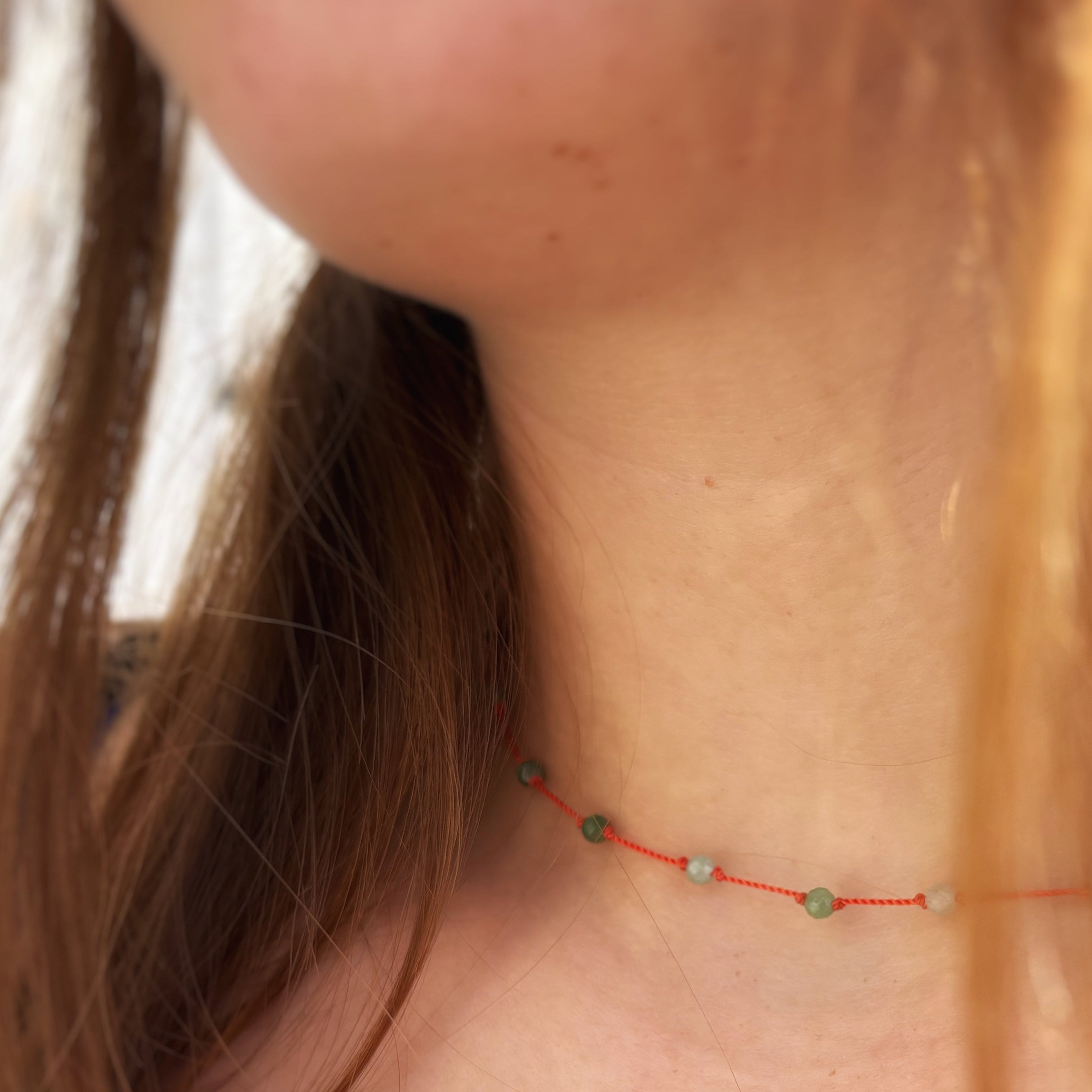 Collier Le Lien en émeraude naturelle porté autour du cou, détail rapproché