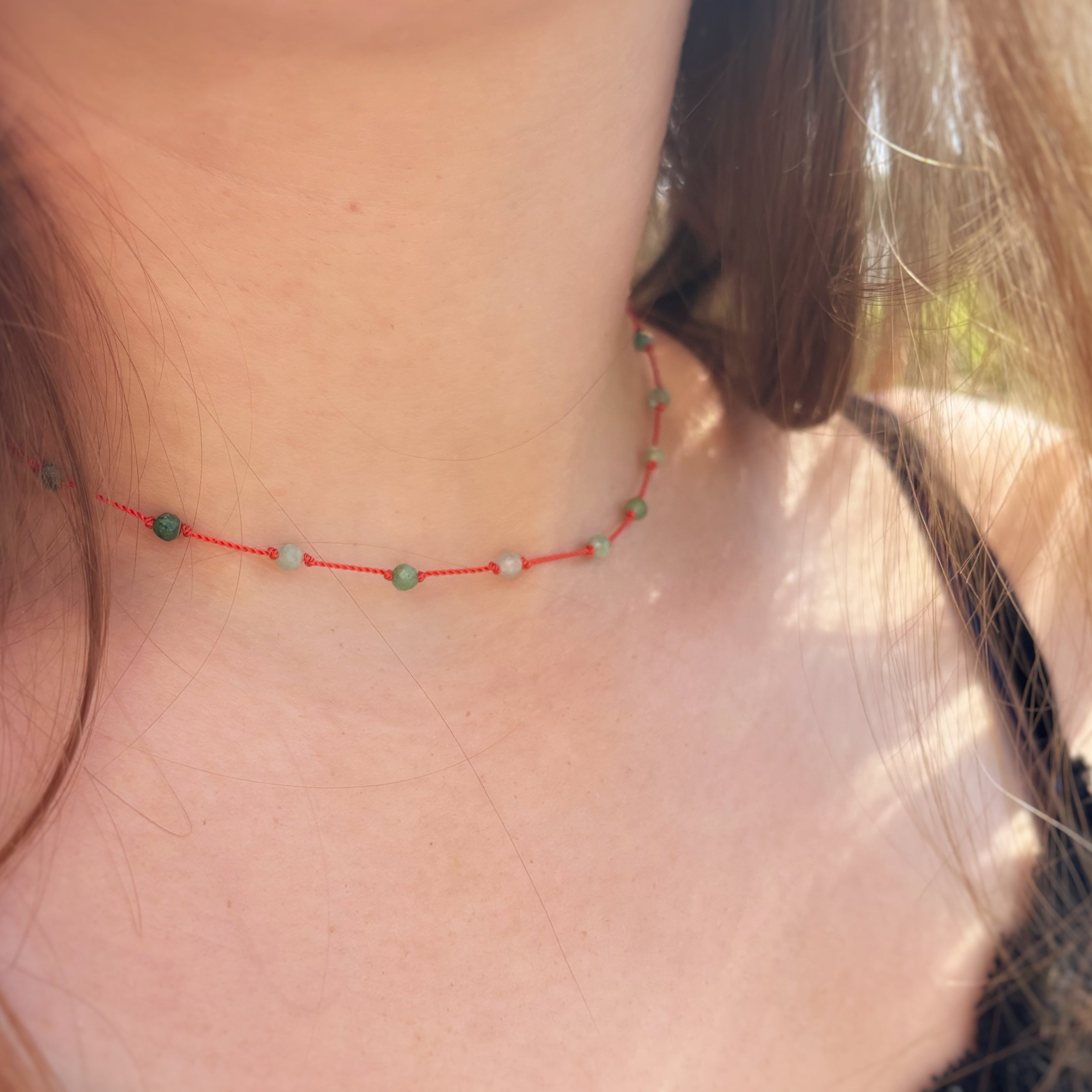 Collier Le Lien en émeraude naturelle porté en extérieur, lumière naturelle