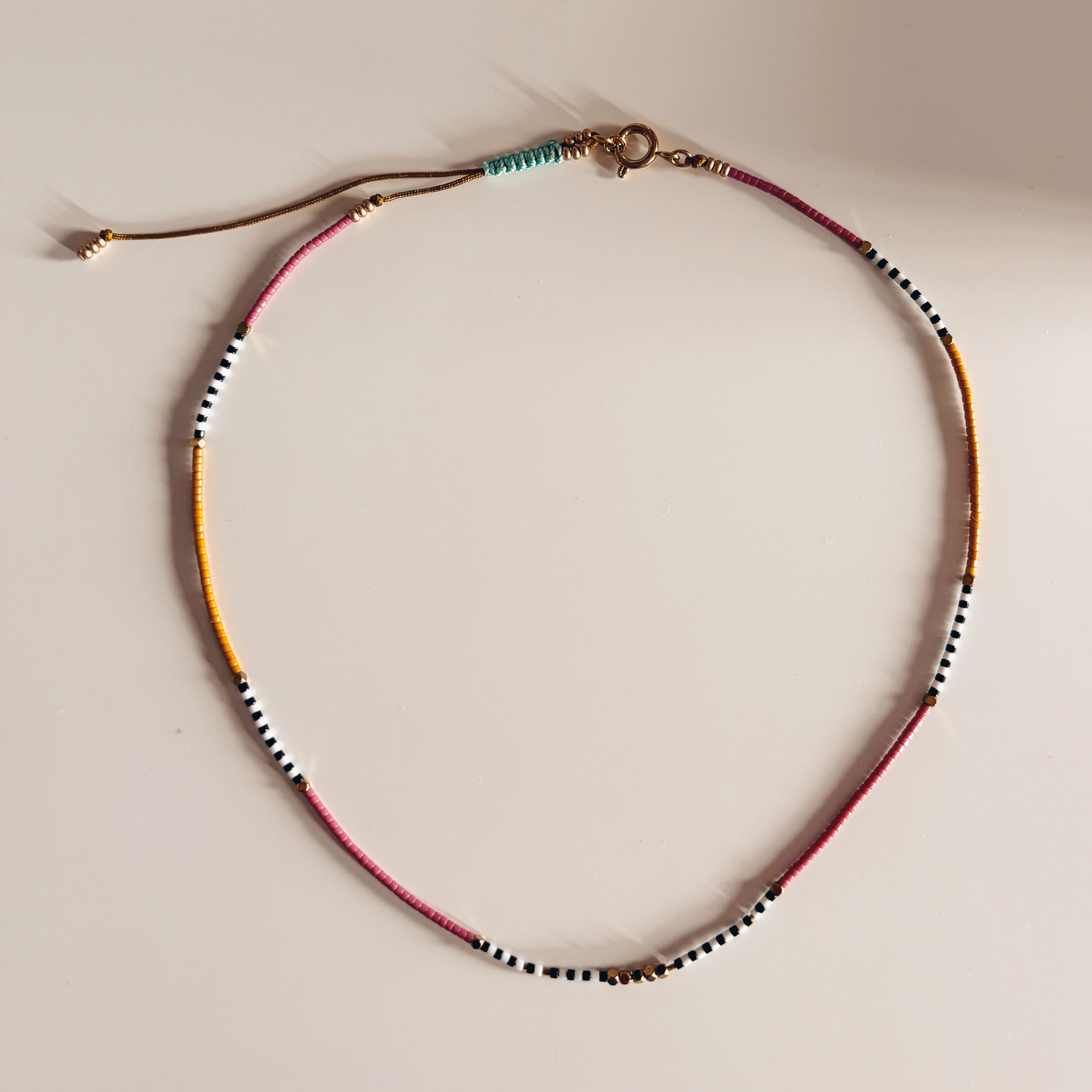 Collier ras de cou surfeur HIPPY coloré posé à plat - bijou festival bohème Ibiza